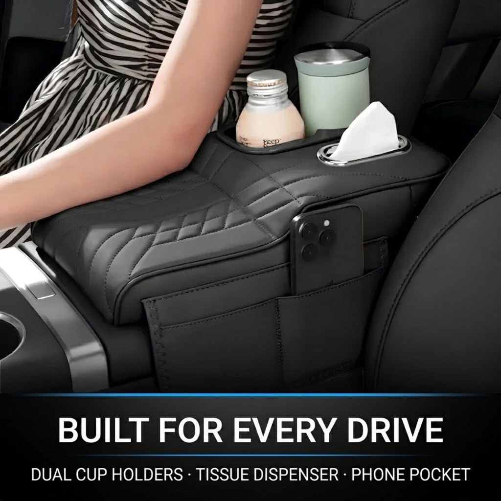 A black quilted car center console organizer with a phone pocket, tissue dispenser, and dual cup holders, shown in a car interior with a woman's arm resting on it. Text at the bottom reads 'BUILT FOR EVERY DRIVE' and 'DUAL CUP HOLDERS • TISSUE DISPENSER • PHONE POCKET'.