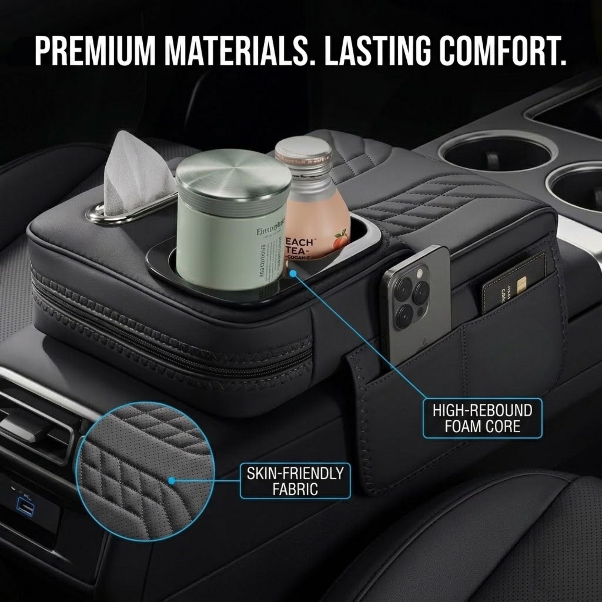 A black quilted car centre console organiser with a phone pocket, tissue dispenser, and dual cup holders, shown in a car interior filled with items. Text and callouts read 'SKIN-FRIENDLY FABRIC' and 'HIGH-REBOUND FOAM CORE'.