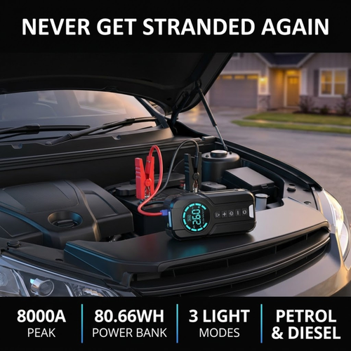 Compact Jump Starter Kit with red and black clamps connected to a car battery under an open bonnet in a driveway at dusk