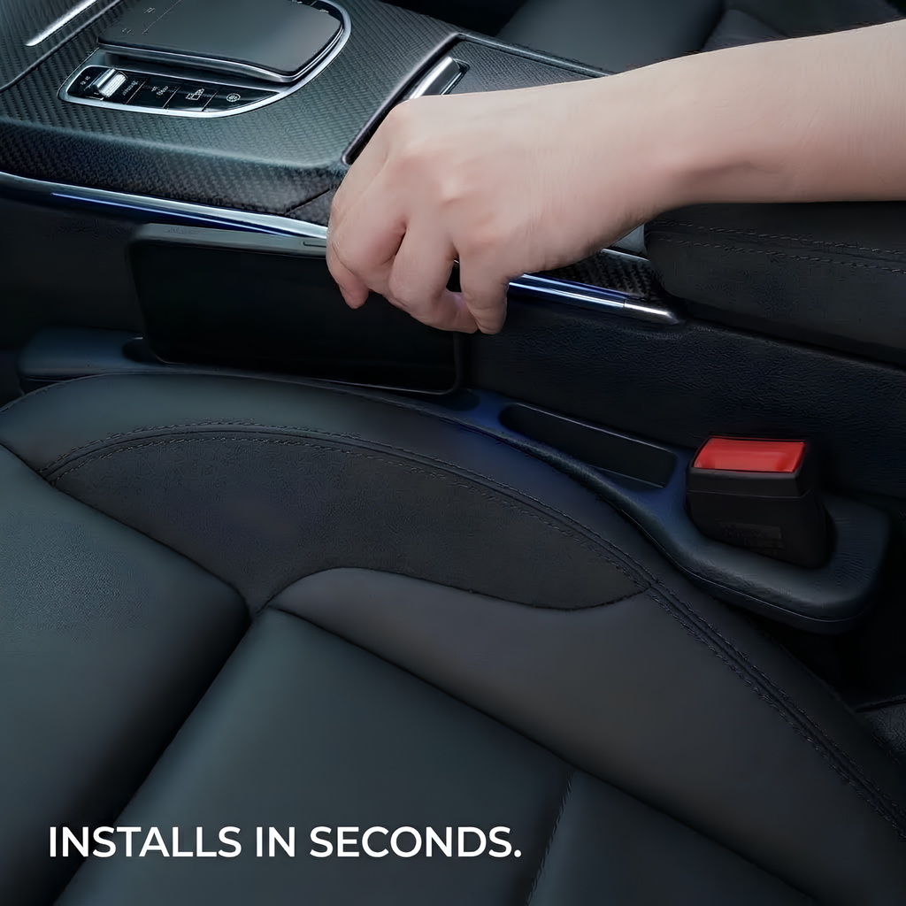 A close-up of a person's hand installing a black rectangular automotive accessory into the center console area of a car interior with black leather seats. White text at the bottom reads 'INSTALLS IN SECONDS.