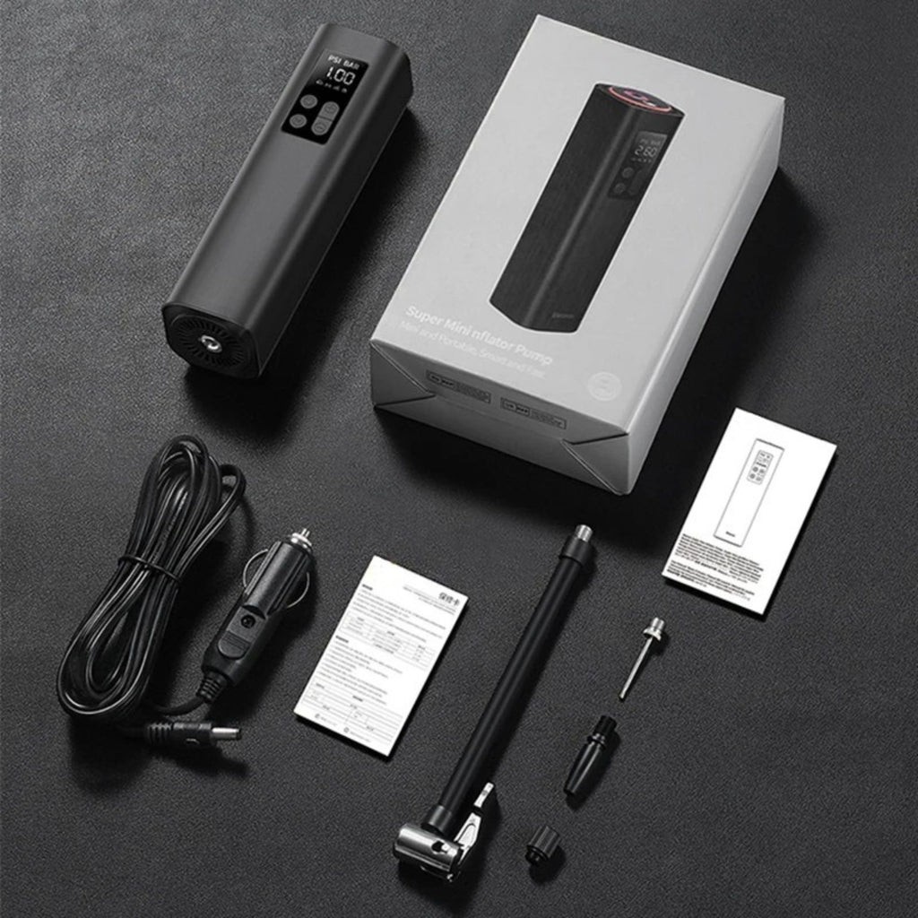 A portable electric pump kit laid out on a dark textured surface, including the black pump body with digital display, its white retail box, power cord, mounting hardware, and instruction sheets.