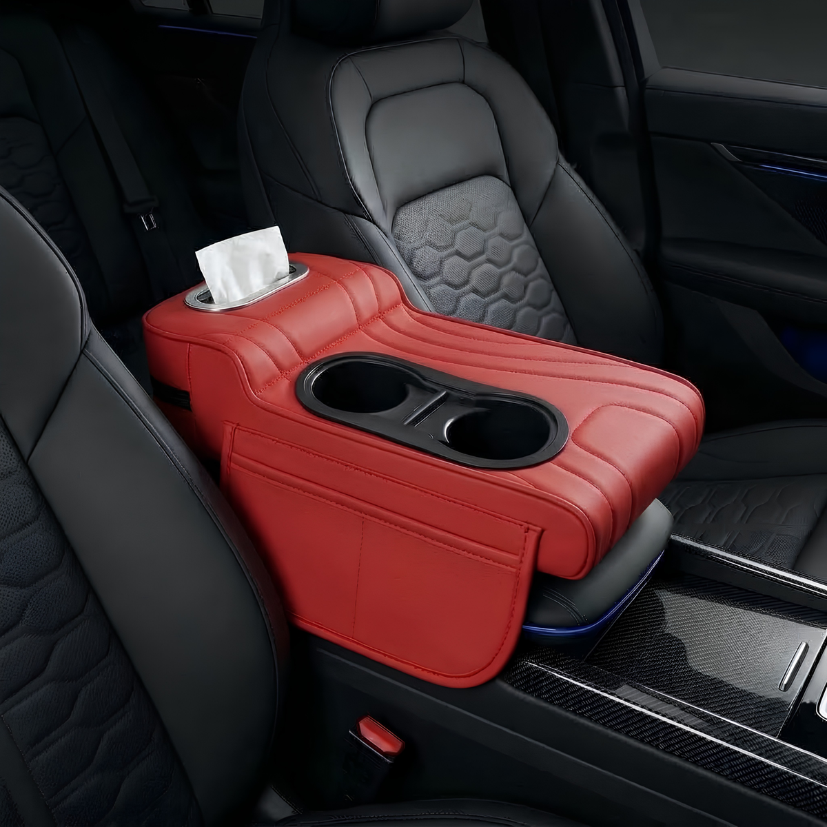 A red car center console armrest organizer placed between two black leather front seats, featuring two black cup holders and a tissue dispenser slot with a white tissue.