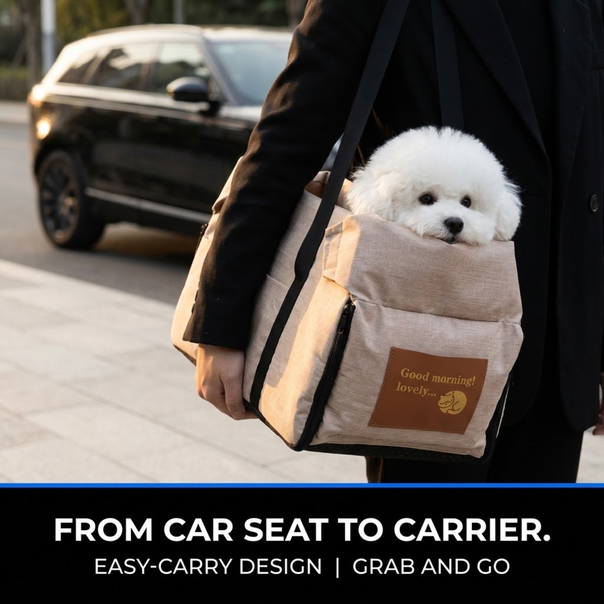 A small white dog sits in a beige pet carrier bag carried by a person wearing a black coat, with a blurred black SUV in the background. The bag has a brown patch that reads 'Good morning, lovely.