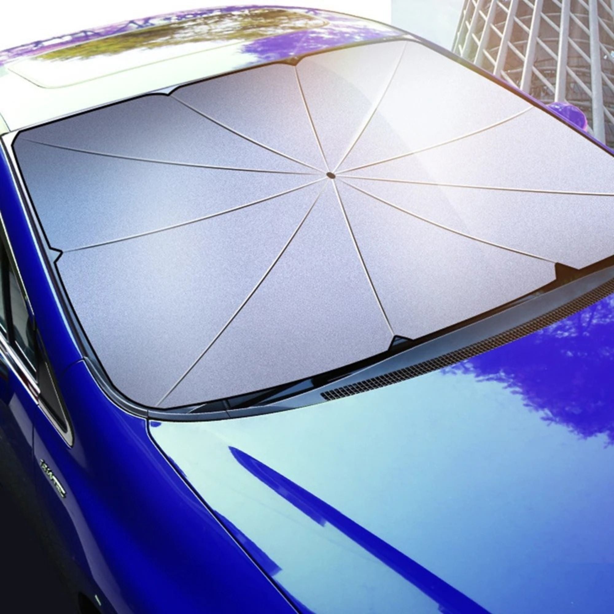 Foldable Windscreen Sun Umbrella opened and fitted to a car windscreen from an outdoor angled view, showing the reflective canopy covering the full glass