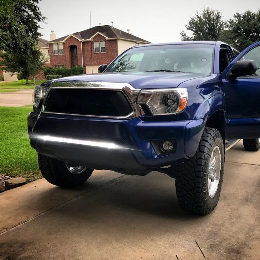 Blue truck with LED light bar mounted on front bumper in a driveway