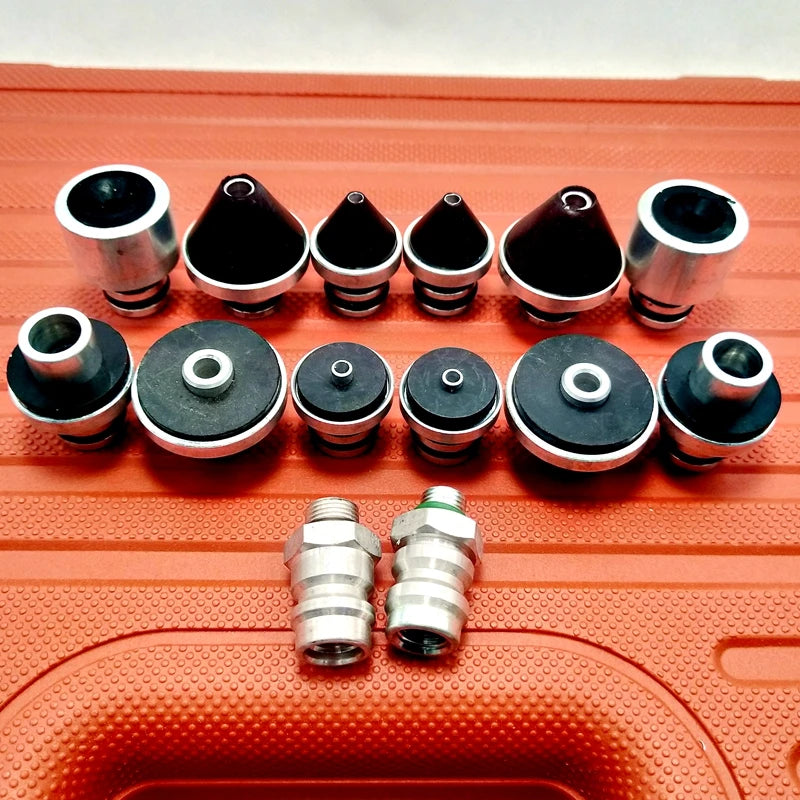 A/C Leak Test Plug Kit metal and rubber sealing plugs with two threaded fittings laid out on the red case