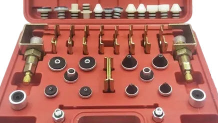 An open red plastic tool case displaying a set of leak detection tools and adapters, with text labels reading 'Plastic plug 12pcs' and 'Metal plug 12pcs' on a white background.