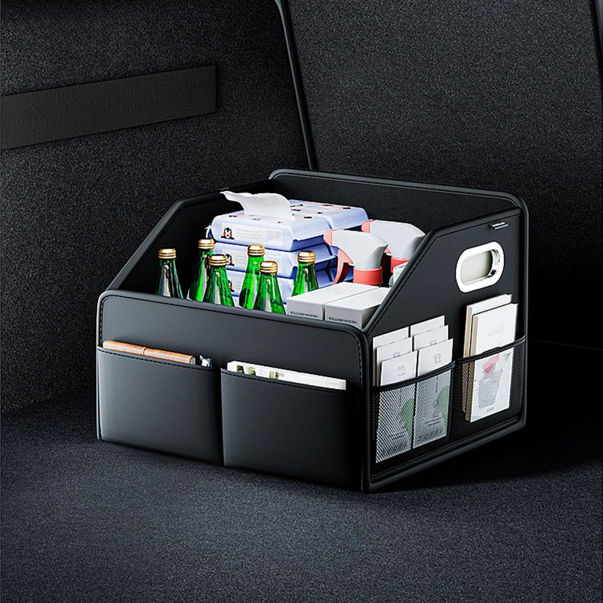 Black leather car boot organiser with drink bottles and accessories stored neatly in a vehicle trunk