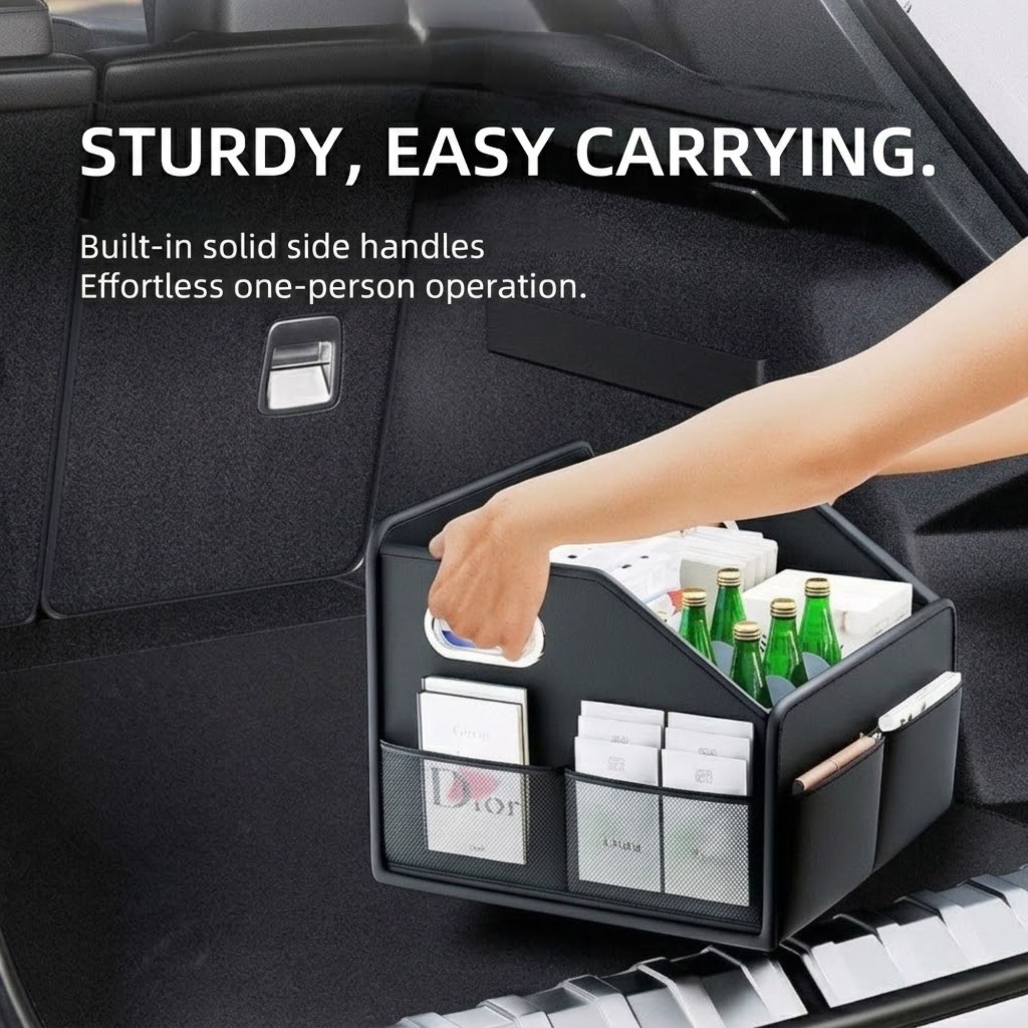Hand lifting leather car boot organiser by its built-in side handle demonstrating easy one-person carrying
