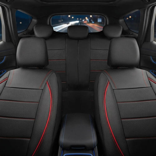 Black car seat covers with red contrast stitching installed on the front and rear seats of a vehicle interior, viewed from the back seat looking forward.