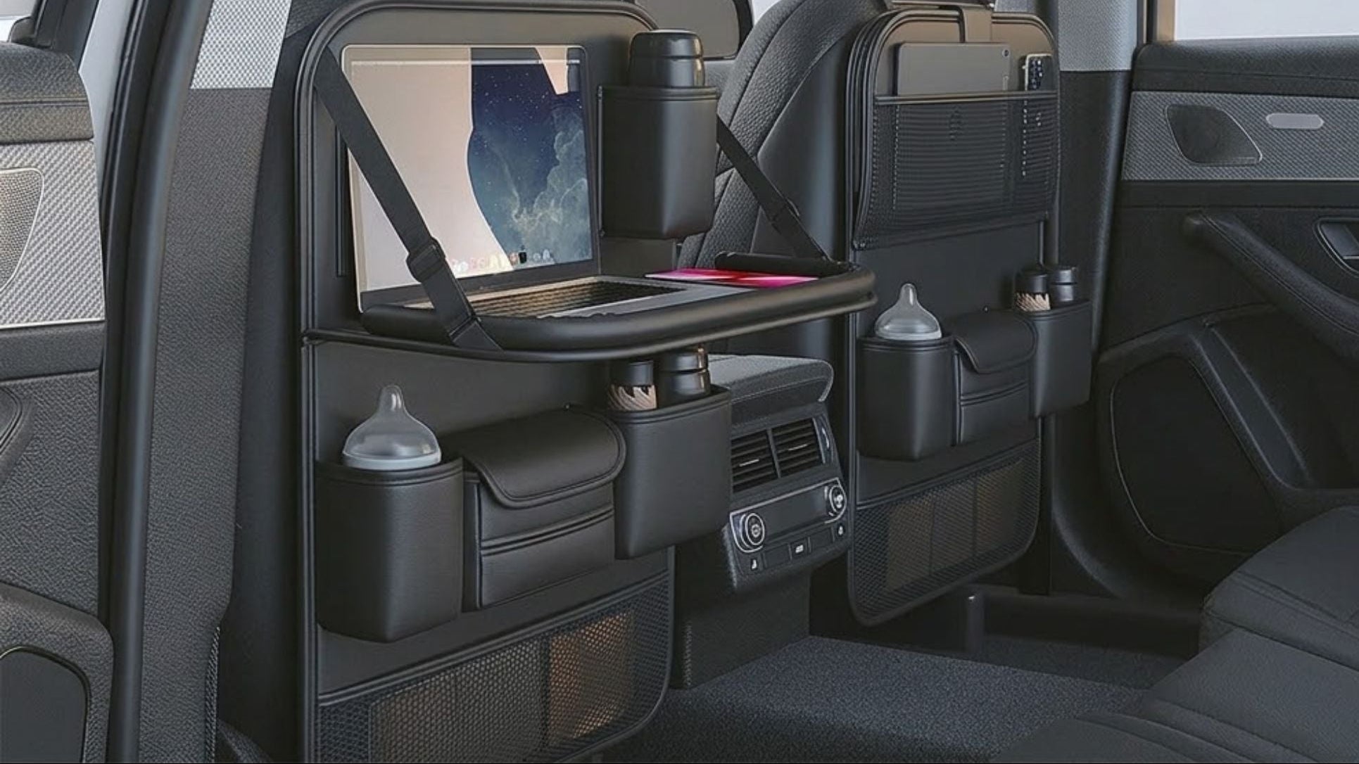A car interior showing a black folding storage system mounted behind the front seats, with text reading 'Upper and lower folding storage board' and 'Two types of storage forms.' The setup includes a tabletop, cup holders, side pockets, and a screen holder, demonstrated in open and folded positions.