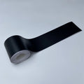 Roll of Matte Black Trim Wrap vinyl film partially unrolled, angled view on a white background