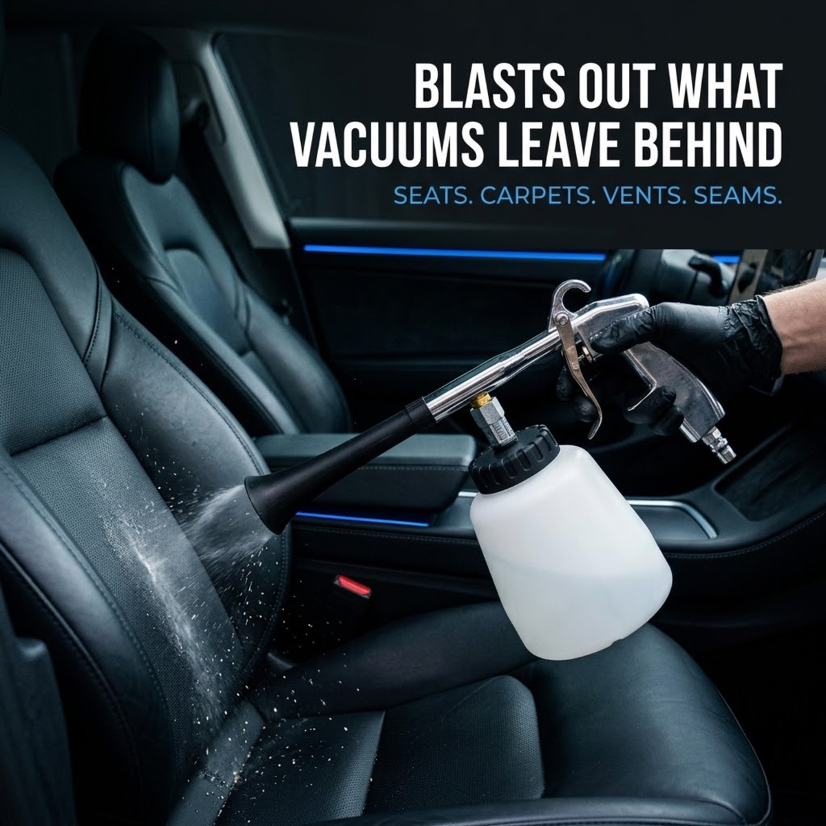 Gloved hand using the Pneumatic Detail Cleaning Gun to spray cleaning mist onto a black leather car seat