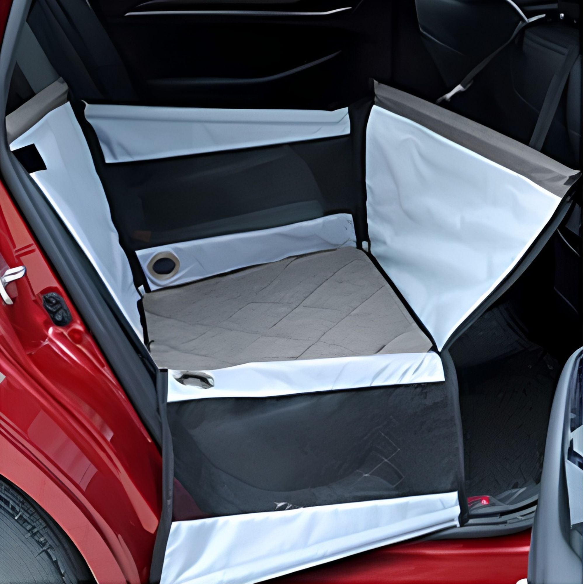 Empty grey portable pet car seat installed in the back seat of a car, angled interior view