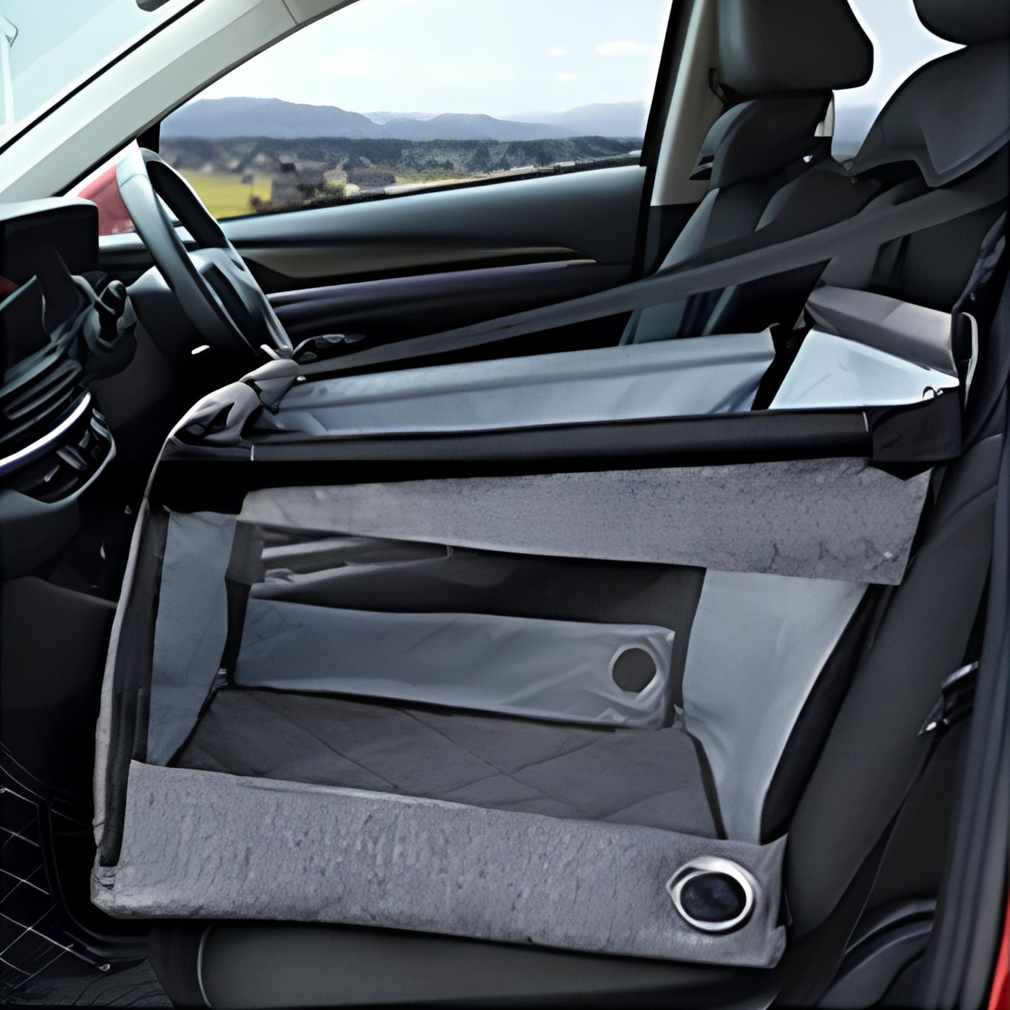 Empty grey portable pet car seat installed on a car front passenger seat with seatbelt threaded through