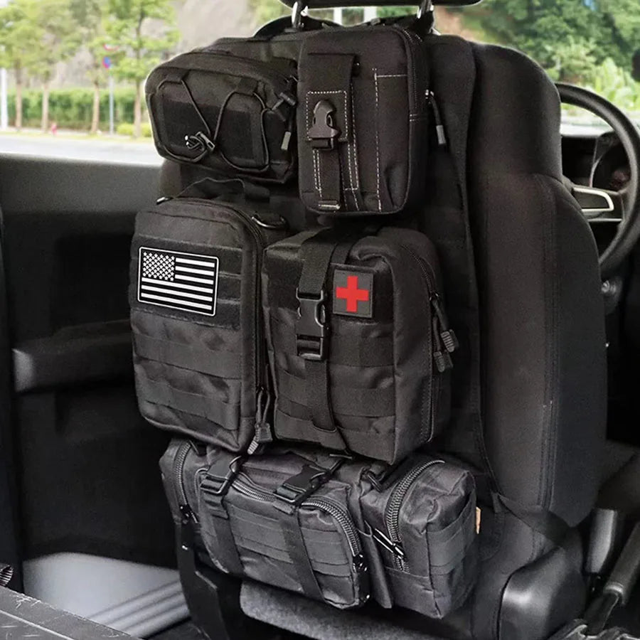 Black tactical car back seat organiser installed and hanging on a vehicle headrest, fully loaded with gear pouches.