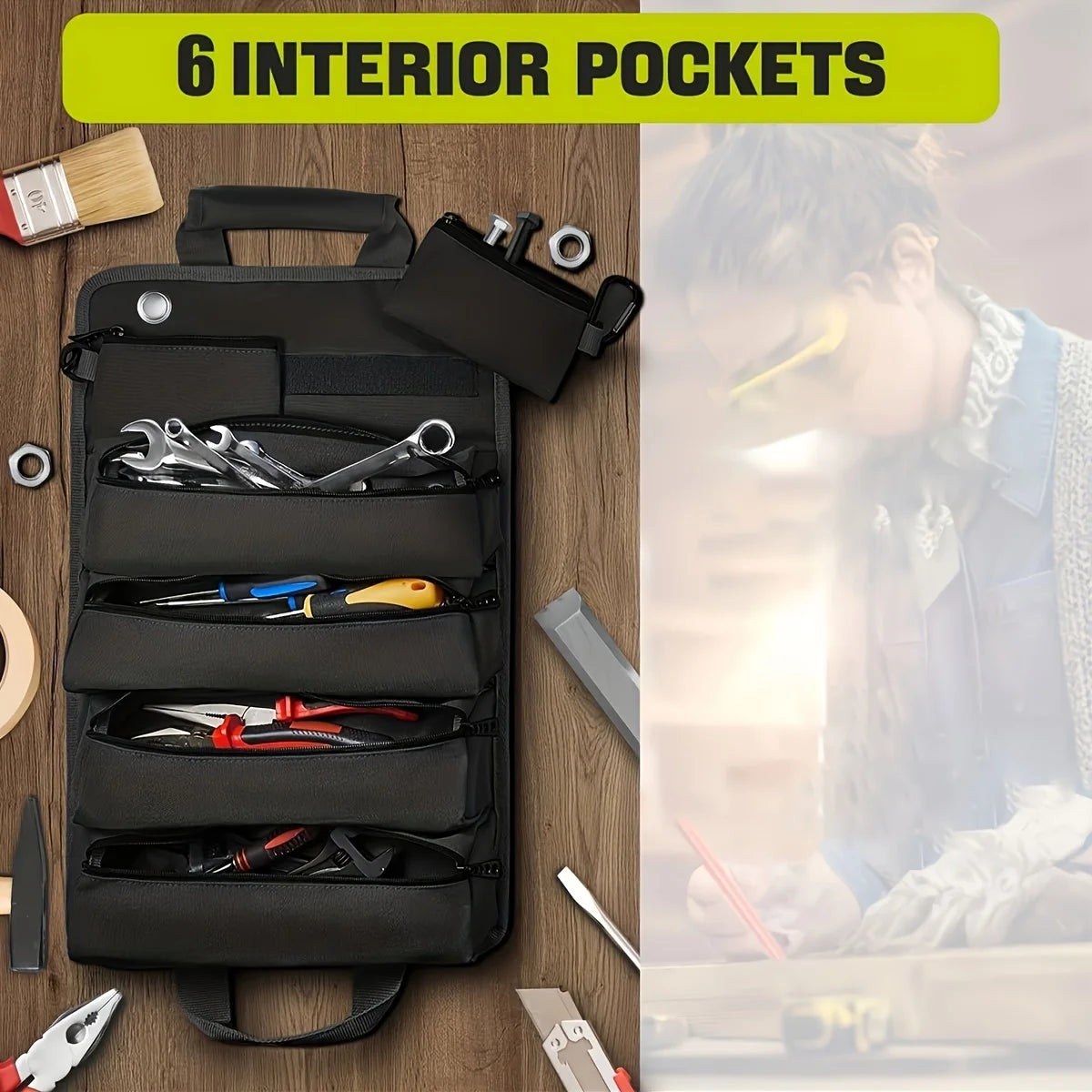 Black Canvas Tool Roll Organiser laid flat on a wooden workbench among wrenches, screwdrivers and pliers filling its interior pockets, with a small attached zip pouch.