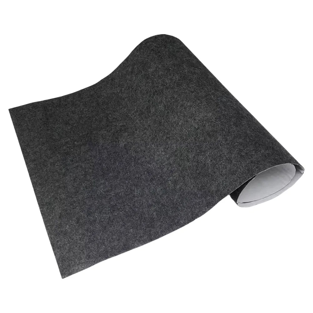 Charcoal self-adhesive felt lining sheet rolled at one end on a white background