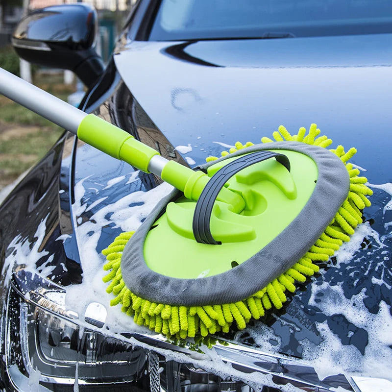 Green and gray car cleaning brush scrubbing a black car
