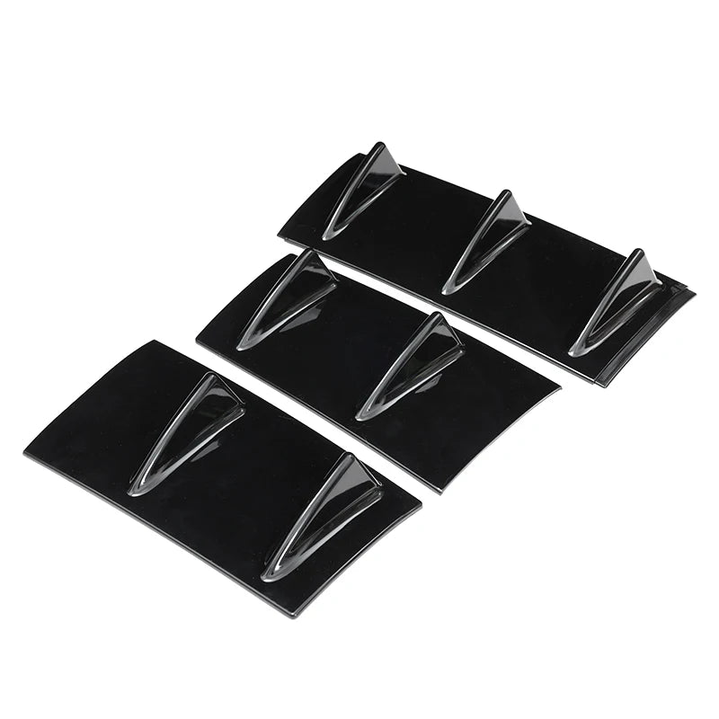 Three sets of gloss black shark fin diffuser panels arranged diagonally on a white background, each with two fin blades