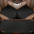 3-Piece Seat Cushion Set in black with red stitching fitted to front and rear seats of a car with tan leather interior