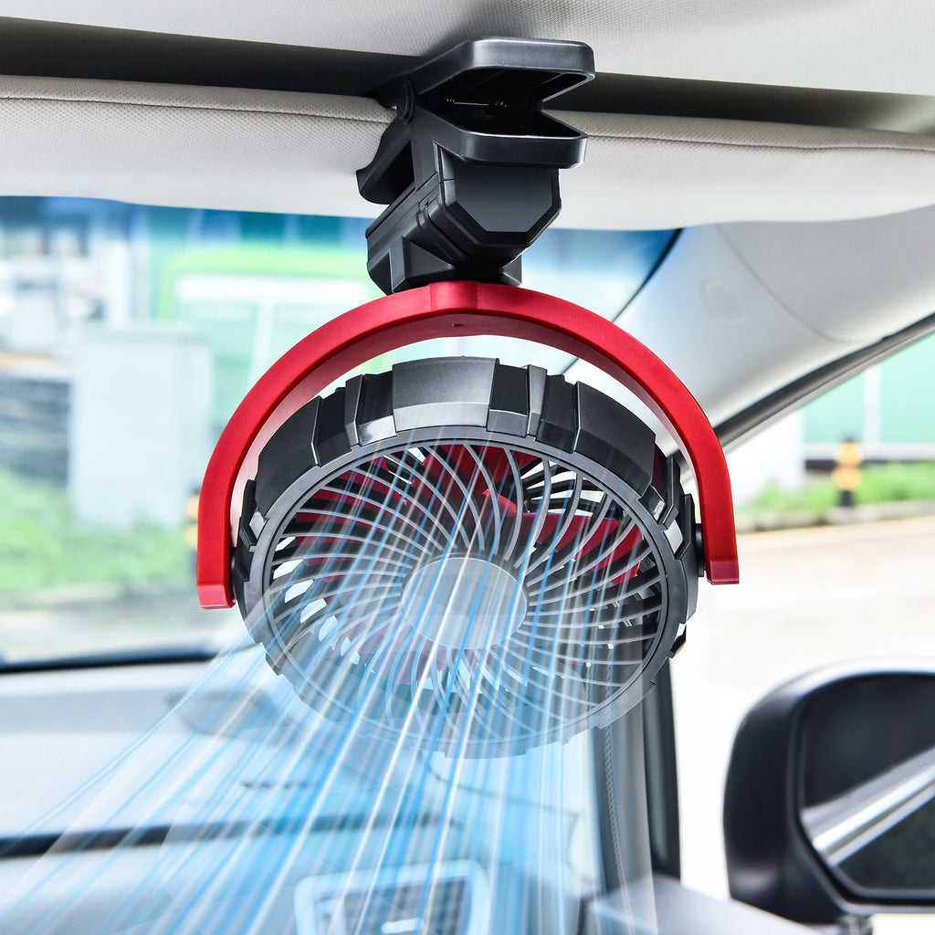 Cordless Clamp Cooling Fan red and black variant clipped to a car sun visor, blowing a strong stream of air across the cabin