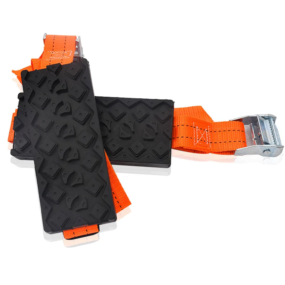 Two Strap-On Tyre Traction Cleats with black rubber grip pads, orange straps and metal cam buckles on a white background