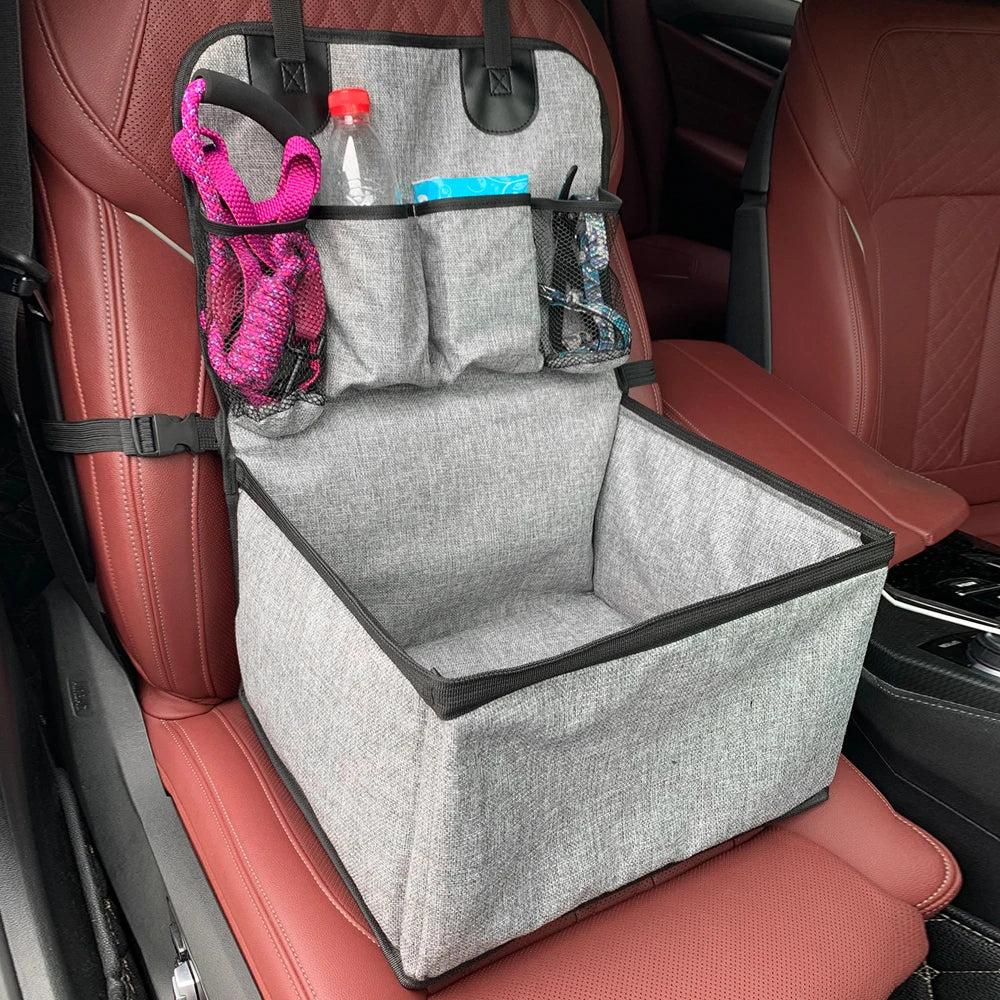 Foldable dog car booster seat secured to a vehicle front seat headrest, shown empty from a front angle.