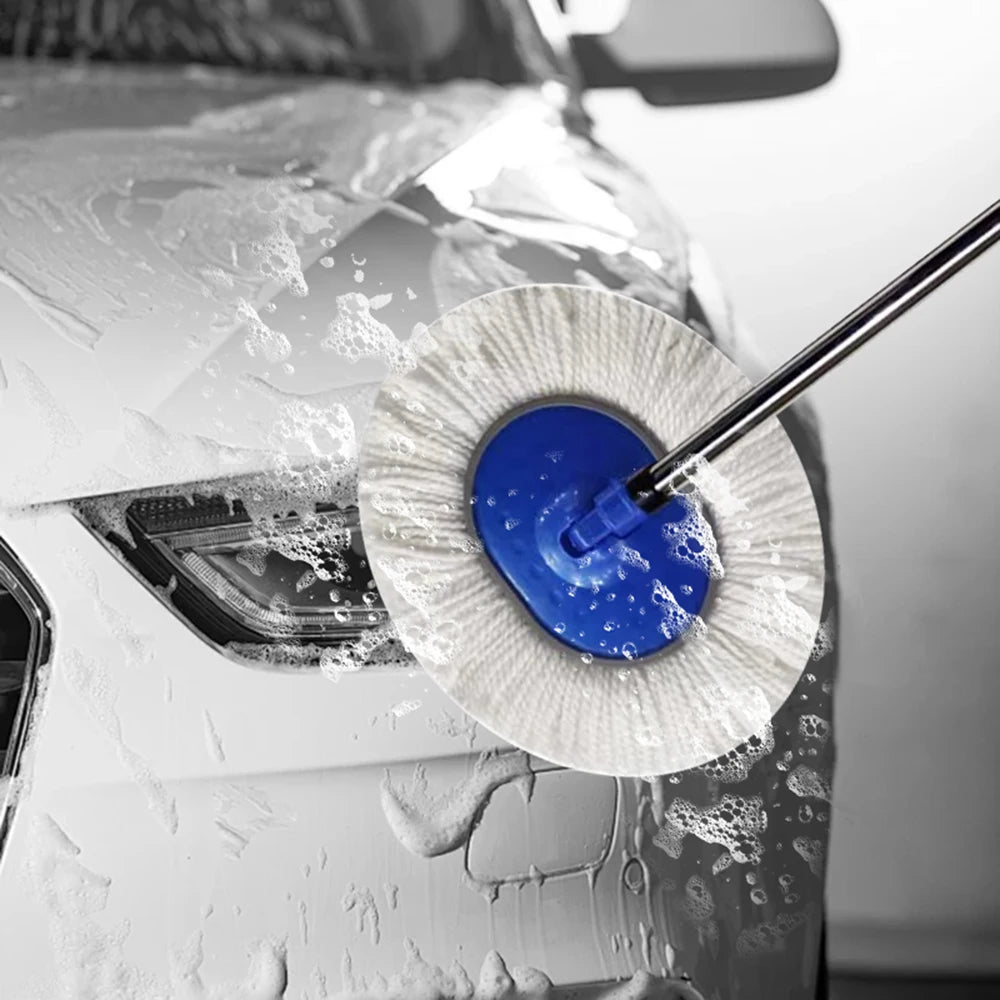 Close-up of the rotating wash brush head scrubbing foam off a white car's bonnet and headlight