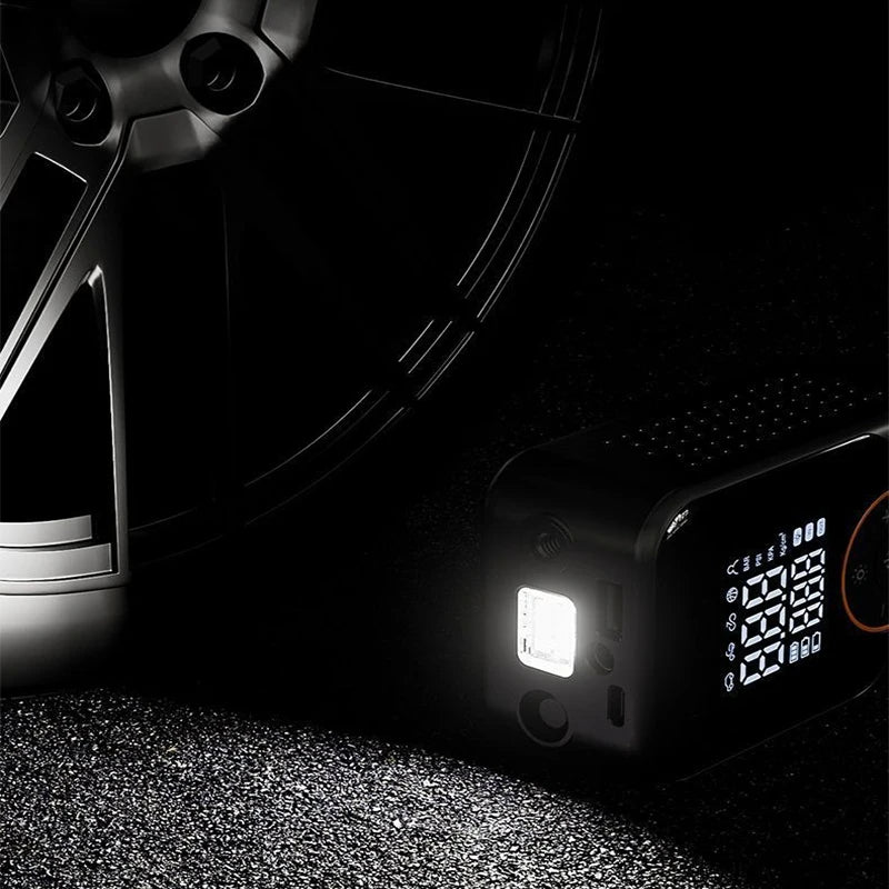Compact Cordless Tyre Inflator built-in LED light illuminating a car wheel on a dark road surface