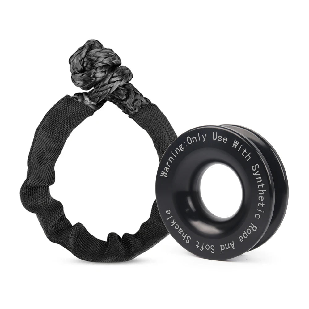 Black soft shackle rope loop beside a black anodised aluminium recovery ring with safety warning text