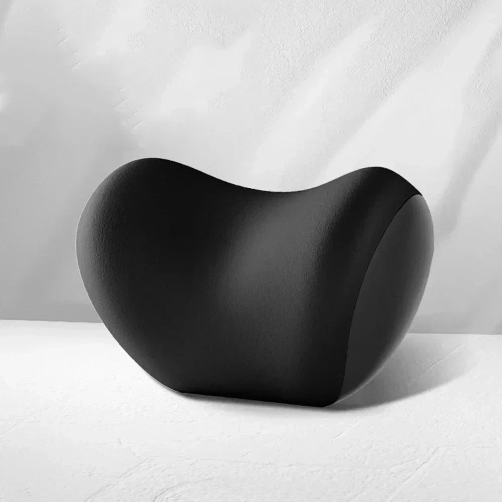 Memory Foam Car Headrest Neck Pillow in black memory foam shown from a side angle on a light grey studio backdrop