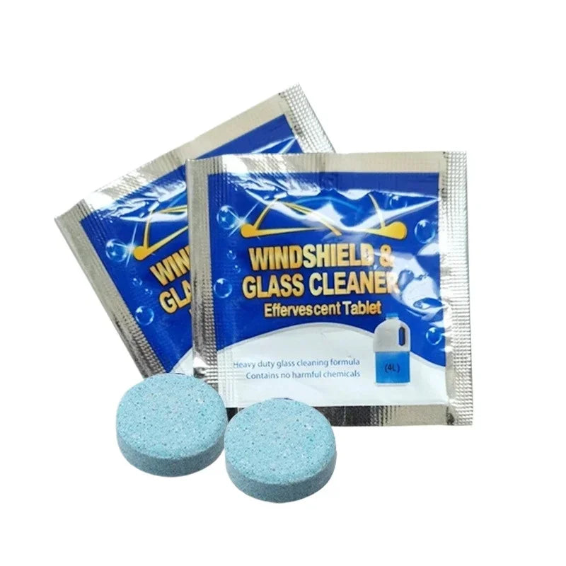 Two foil-sealed Windscreen Washer Fluid Tablets & Concentrated Glass Cleaner sachets beside two loose blue effervescent tablets on a white background