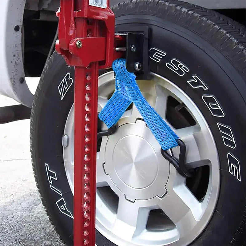 Wheel lifter strap attached to a car wheel rim and scissor jack during a tyre change