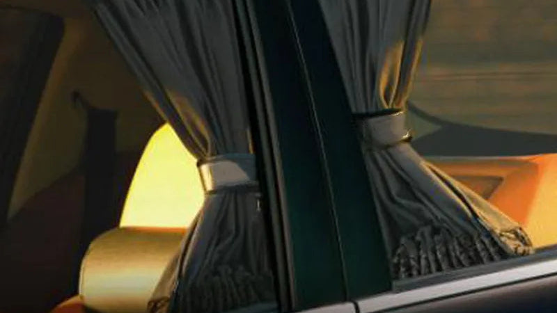 Car interior with curtains drawn over the windows, reflecting a warm glow.