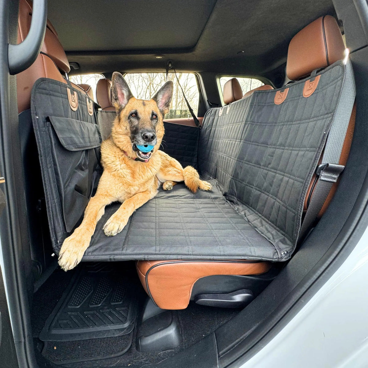 Hard-Base Dog Seat Extender in black installed across the back seat of a car, German Shepherd sitting on the raised flat platform