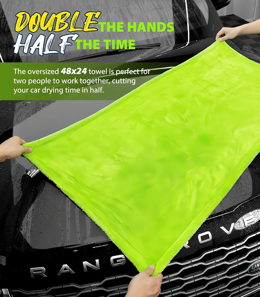 Two people holding an oversized green Large Absorbent Detailing Cloth across the bonnet of a Range Rover to dry the vehicle together.