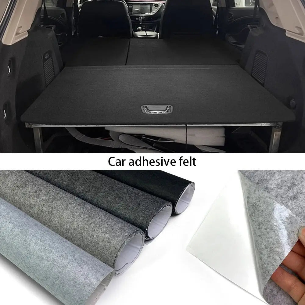Black self-adhesive felt lining fitted to a car boot floor panel, with black, dark grey and light grey rolls
