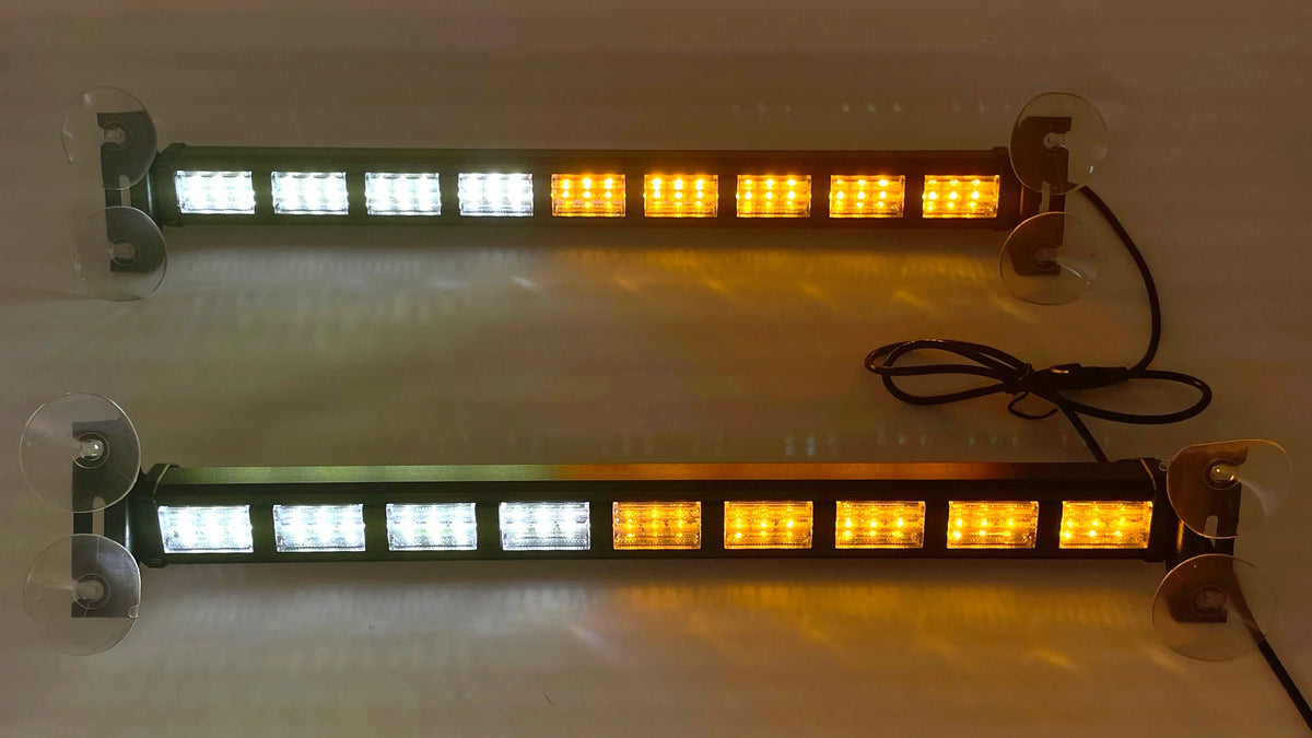 Two long rectangular LED light bars with clear suction cup mounts, shown mounted on a light-colored wall. Each bar has white LEDs on the left and amber/yellow LEDs on the right, with one bar illuminated and a black power cord visible.