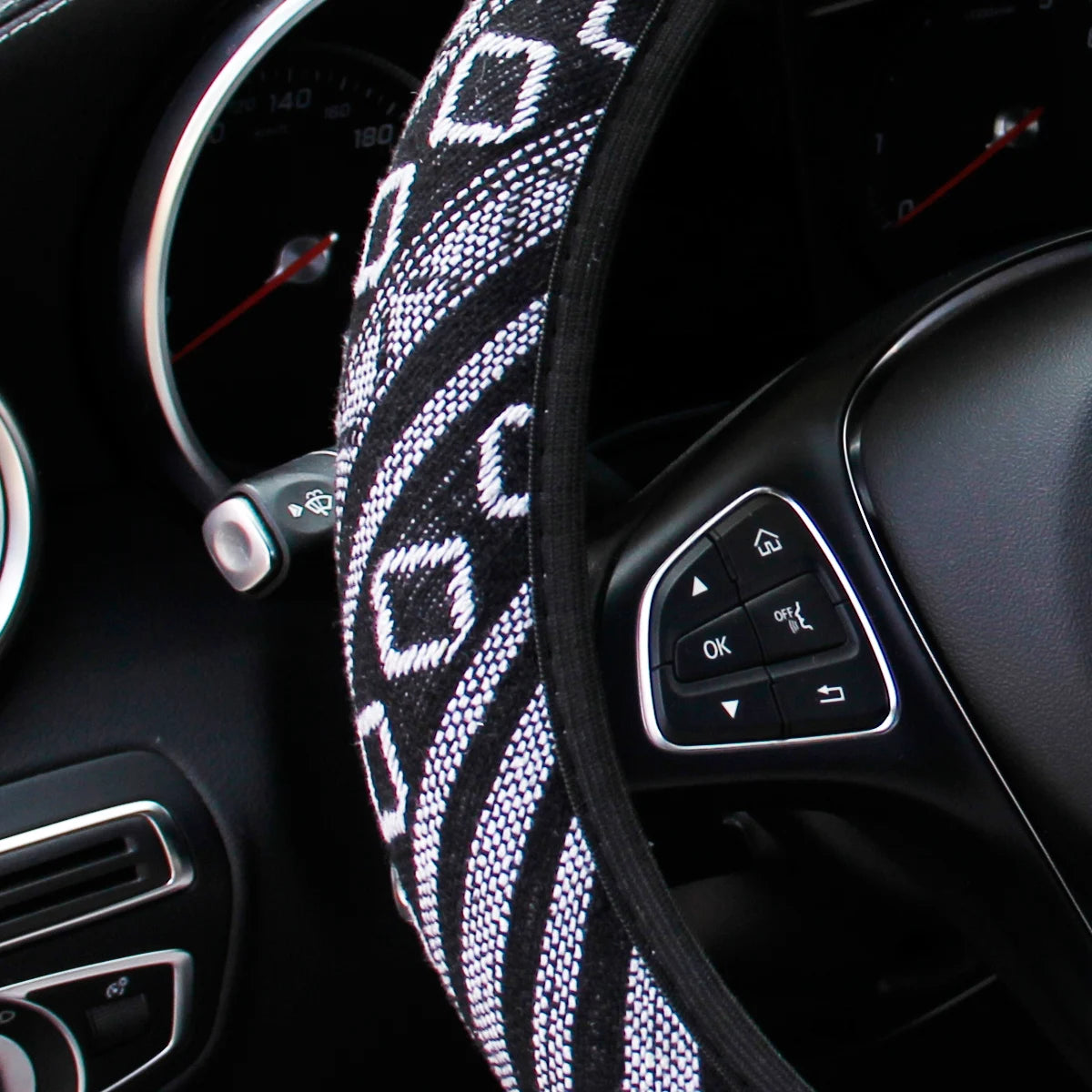 Close-up of the black and white diamond pattern weave on the linen steering wheel cover fitted to a steering wheel