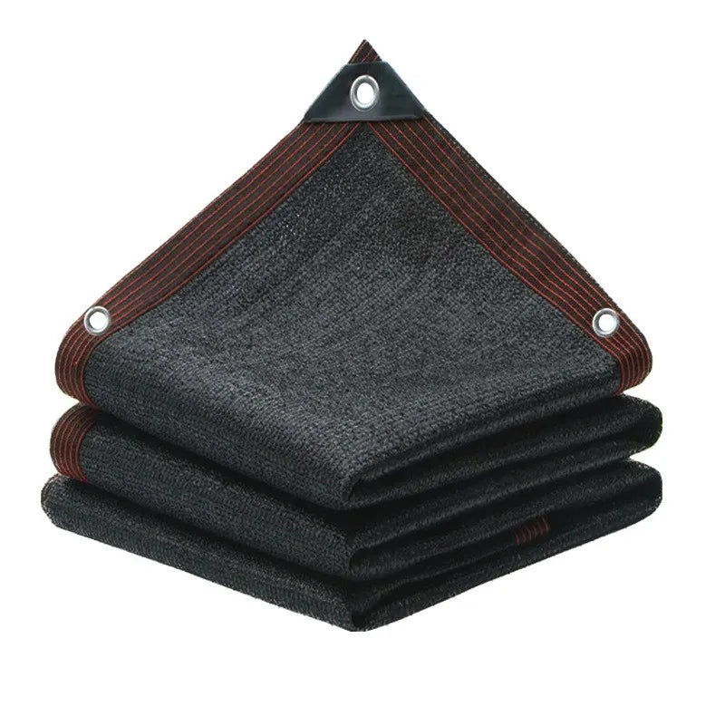 HDPE Sun Shade Net in black, folded with reinforced brown edge binding and metal grommets, on a white background