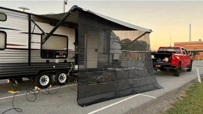 A two-panel photo showing a travel trailer with an extended black mesh awning and side door screen in an outdoor parking lot. A pickup truck is parked behind the trailer, and trees and buildings are visible in the background at sunset.