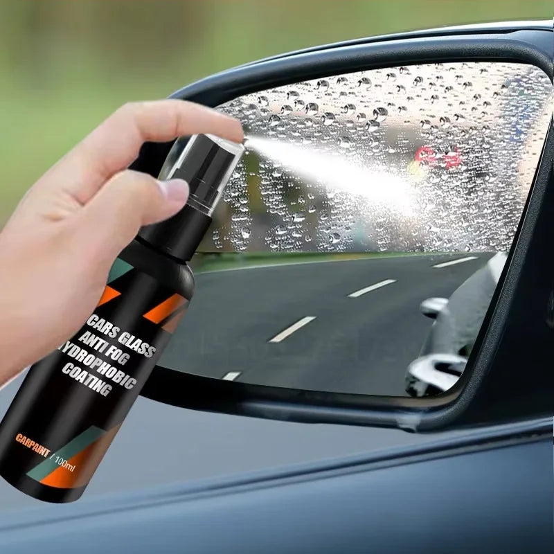 Hand spraying Hydrophobic Glass Shield coating onto a wet car side mirror on a rainy road