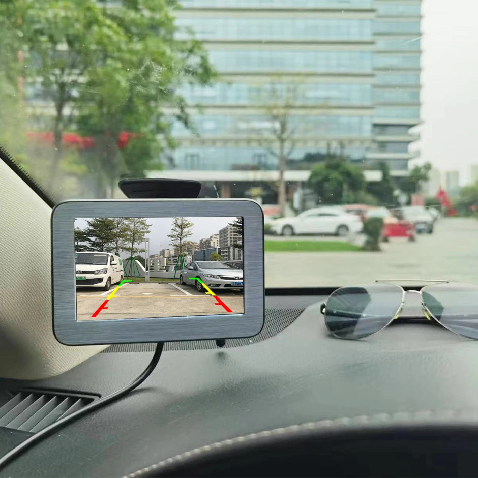 Solar Reversing Camera Kit monitor mounted on a car windscreen showing the rear view with parking guide lines
