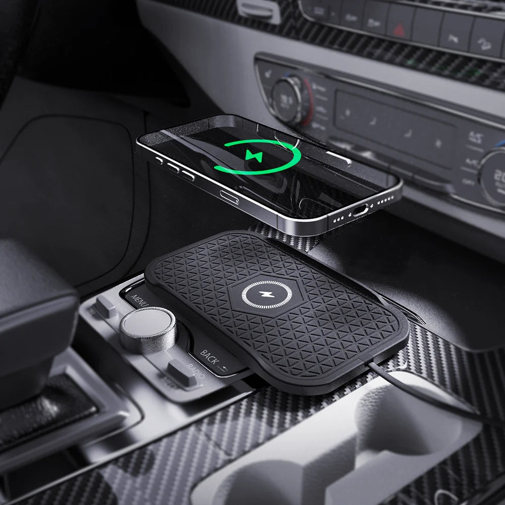 Smartphone charging on a non-slip wireless charging pad on a car centre console