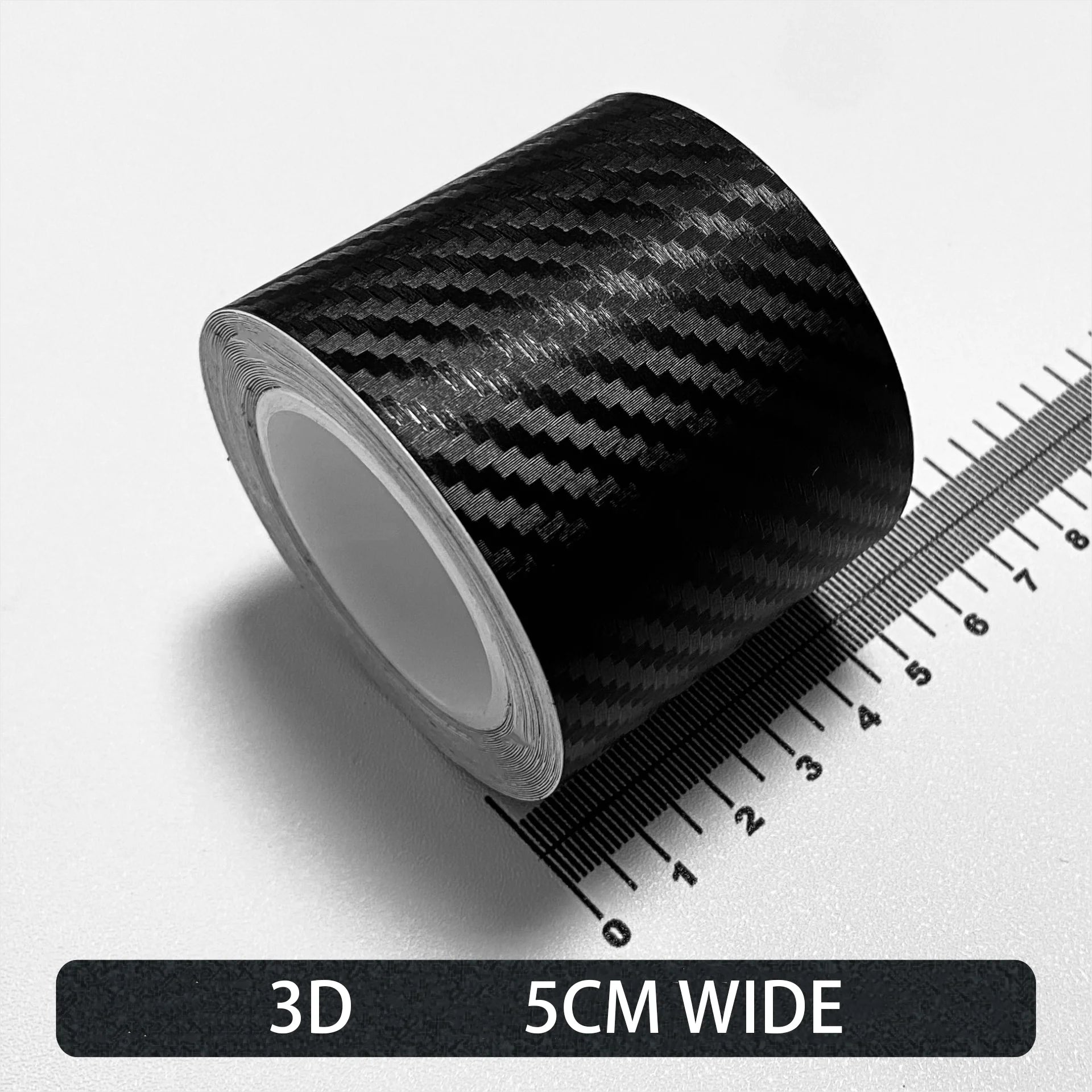 Roll of black Textured 3D carbon fibre wrap tape, 5cm wide, shown on a white background with a ruler for scale.