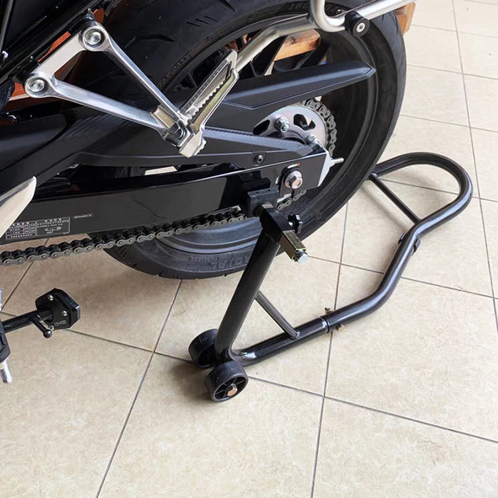 Heavy-Duty Paddock Stand fitted under a motorcycle's rear wheel and swingarm on a tiled workshop floor