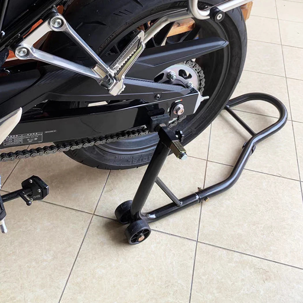 Heavy-Duty Paddock Stand fitted under a motorcycle's rear wheel and swingarm on a tiled workshop floor