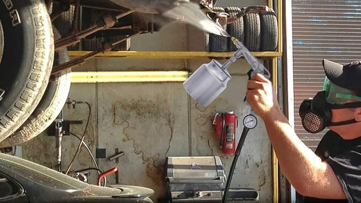 A person in a garage sprays undercoating fluid from a handheld applicator gun onto the underside of a car raised on a lift. Large text on the left describes the rust proofing undercoating gun and its features.
