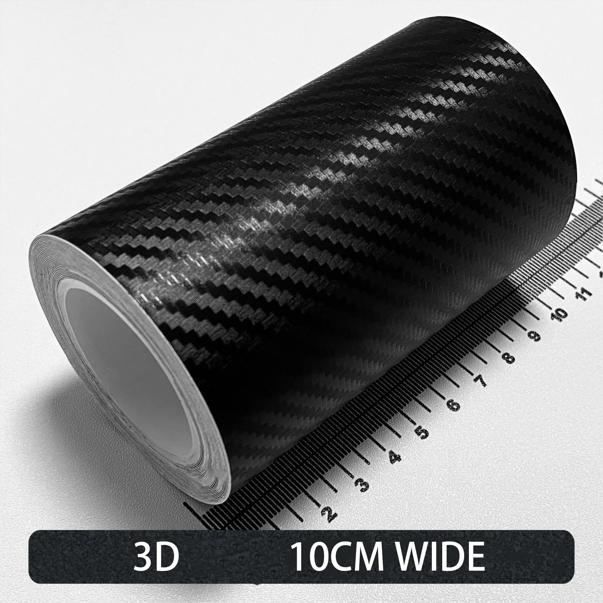 Roll of black Textured 3D carbon fibre wrap tape, 10cm wide, shown on a white background with a ruler for scale.